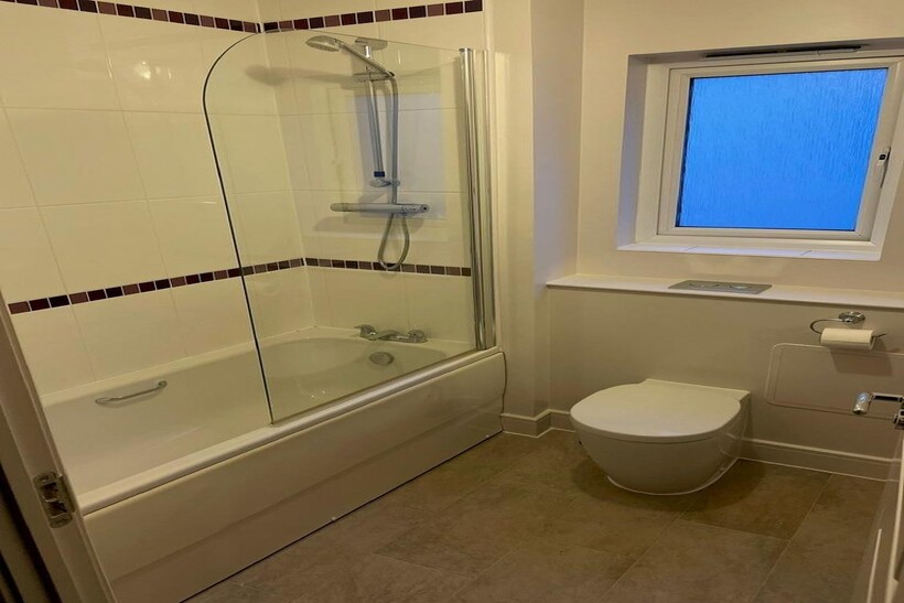 A modern bathroom suite featuring a clean white...