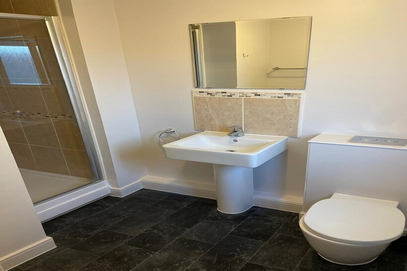 A clean and modern bathroom featuring a walk-in...