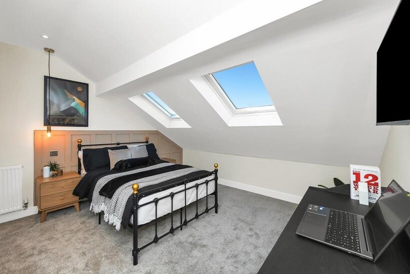 This charming double bedroom features a cozy at...