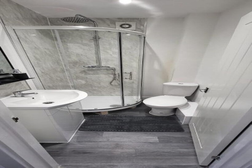 This stylish bathroom features a modern shower ...