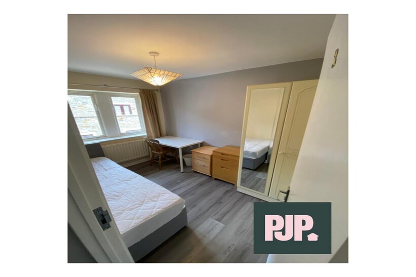 A well-lit and inviting double bedroom with a c...