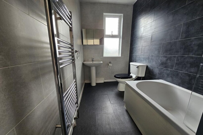 A modern bathroom featuring a deep white bathtu...