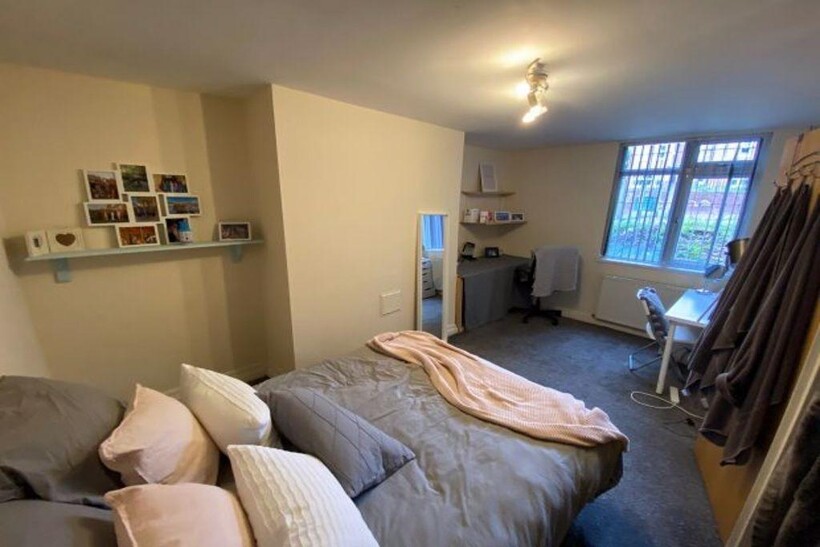 A cozy double bedroom featuring a neatly made b...