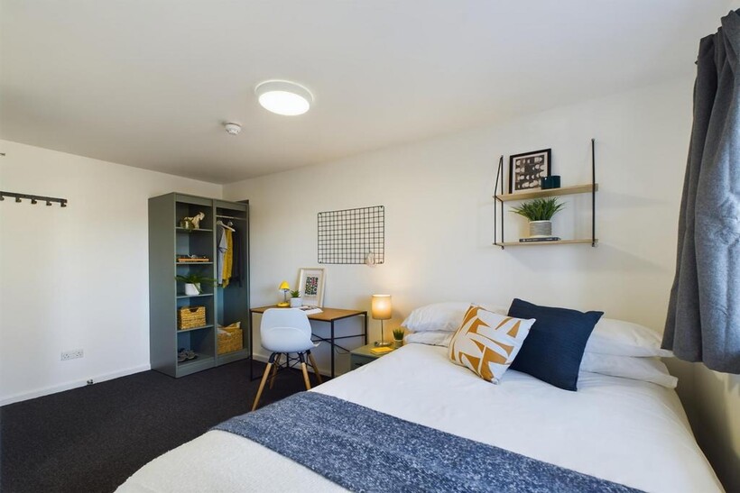 A bright and inviting double bedroom with styli...