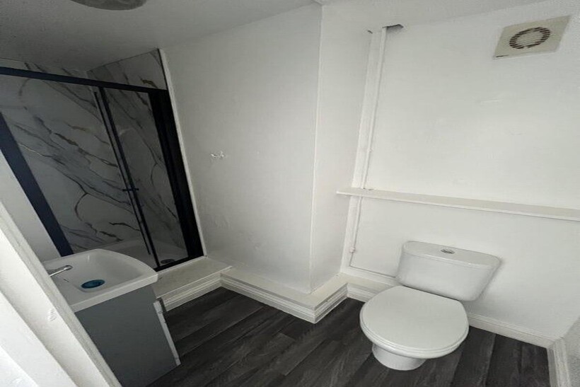 A compact, modern bathroom featuring a white to...
