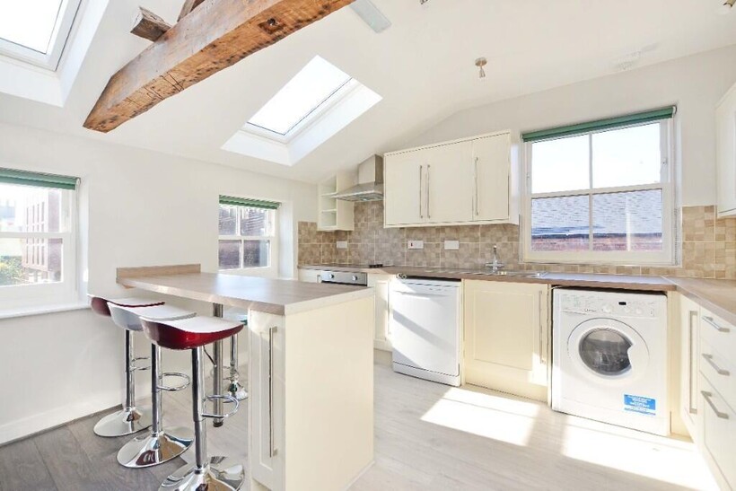 Bright and modern kitchen featuring ample natur...