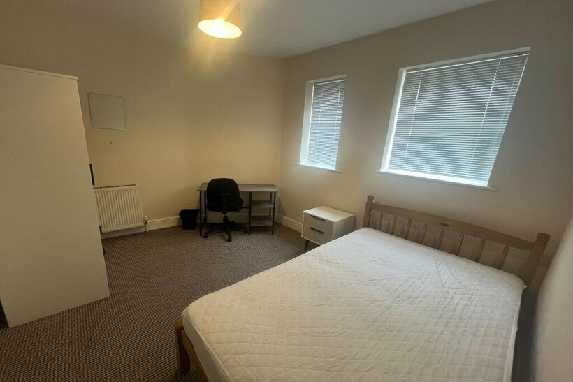 A tidy and bright double bedroom featuring a co...