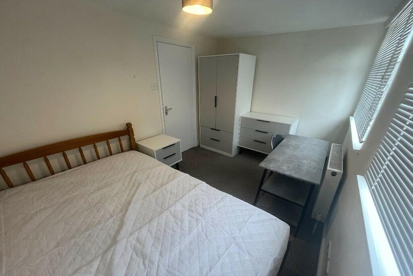 Bright double bedroom featuring a large bed, a ...
