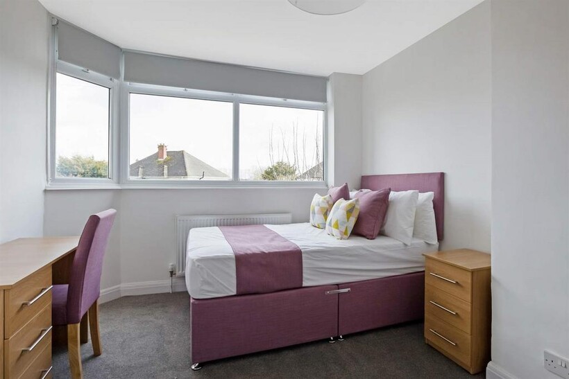 Bright and clean double bedroom featuring a com...