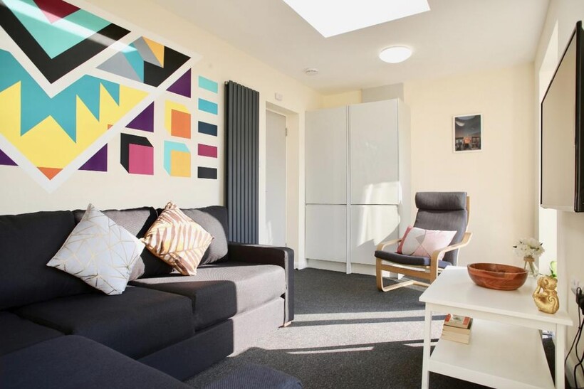 This vibrant living room features a cozy seatin...
