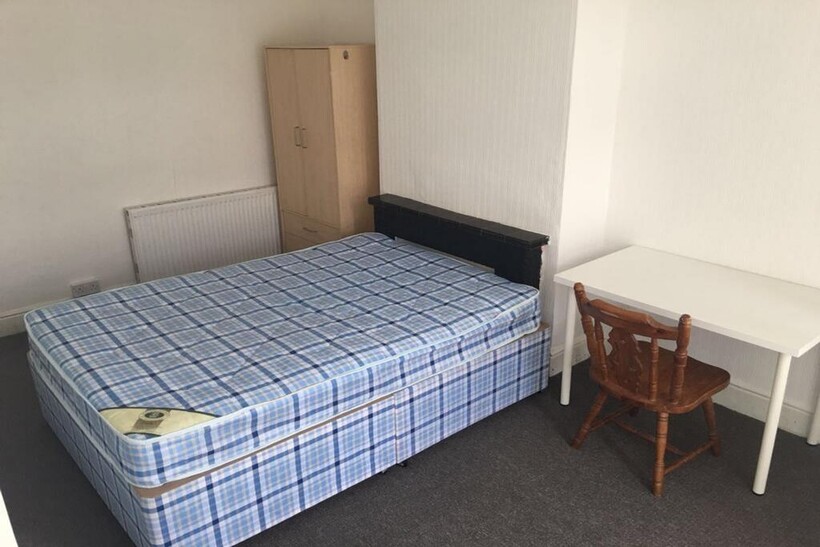 This inviting double bedroom features a comfort...