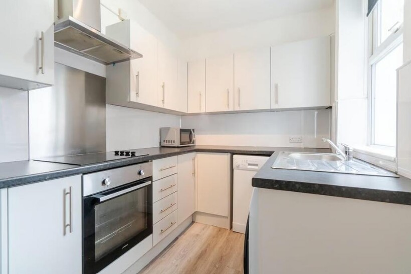 This modern kitchen features sleek cabinetry, a...