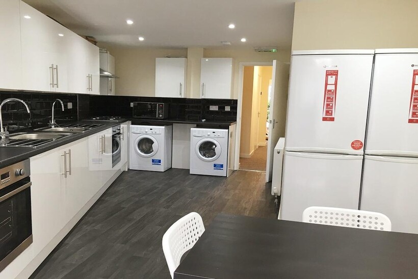 A modern, well-equipped kitchen with sleek whit...