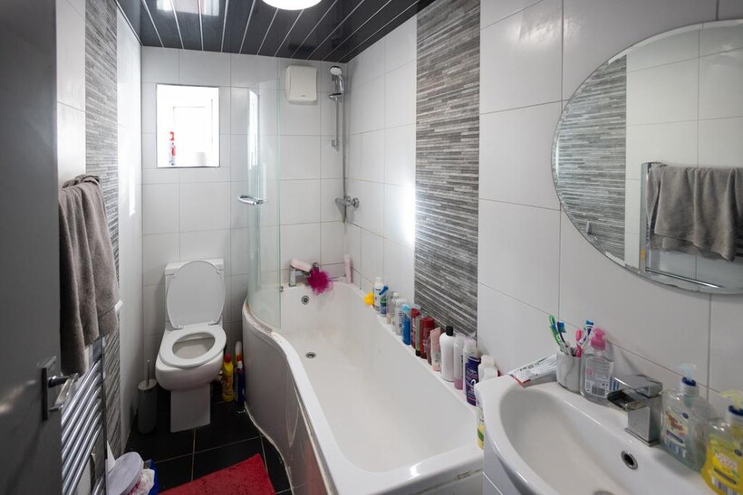 A modern bathroom suite featuring a curved bath...