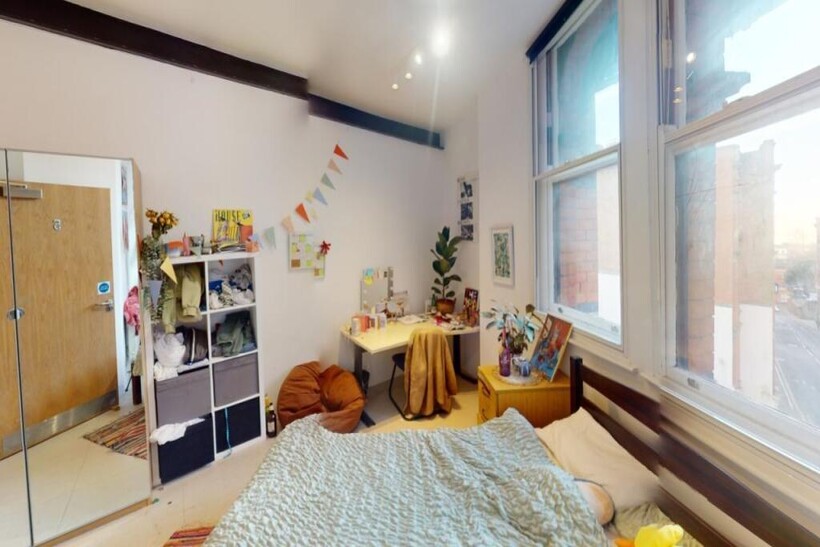 Bright and spacious master bedroom with large w...