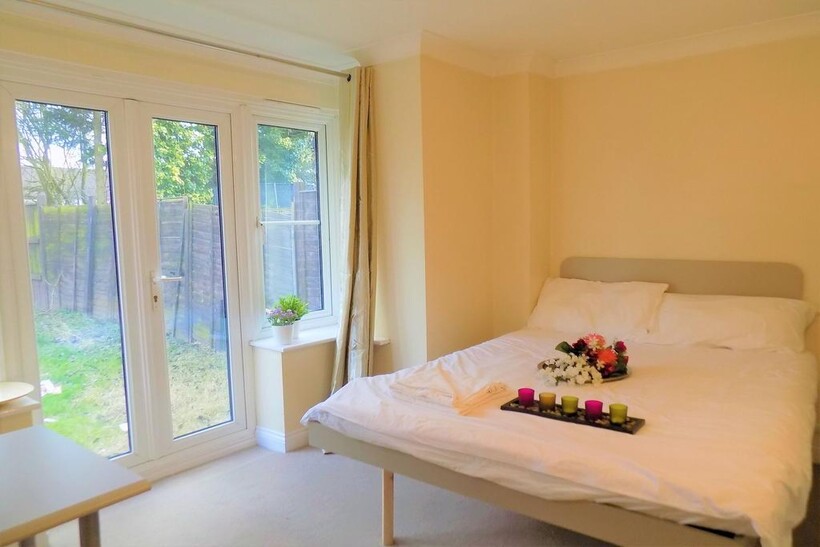 A bright double bedroom featuring a comfortable...