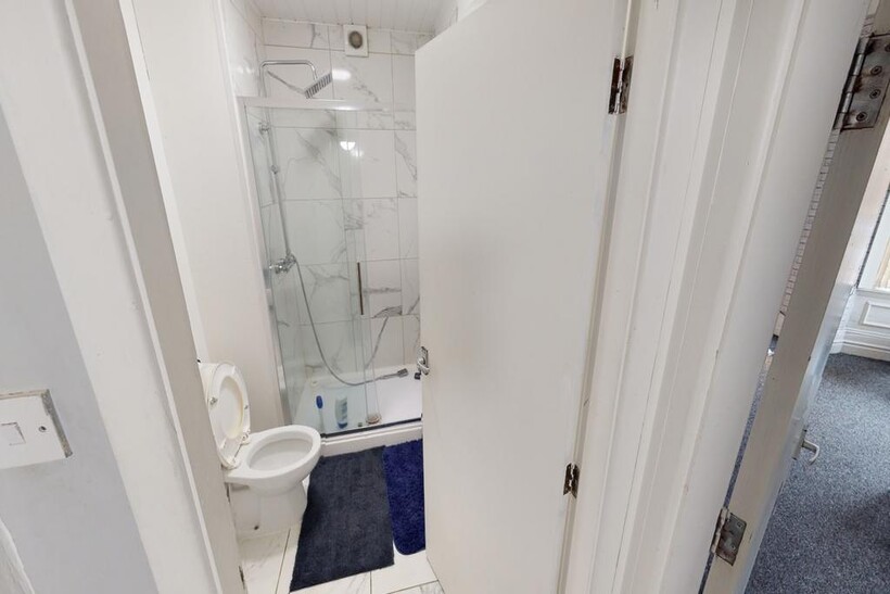 Bright and modern bathroom featuring a glass-en...