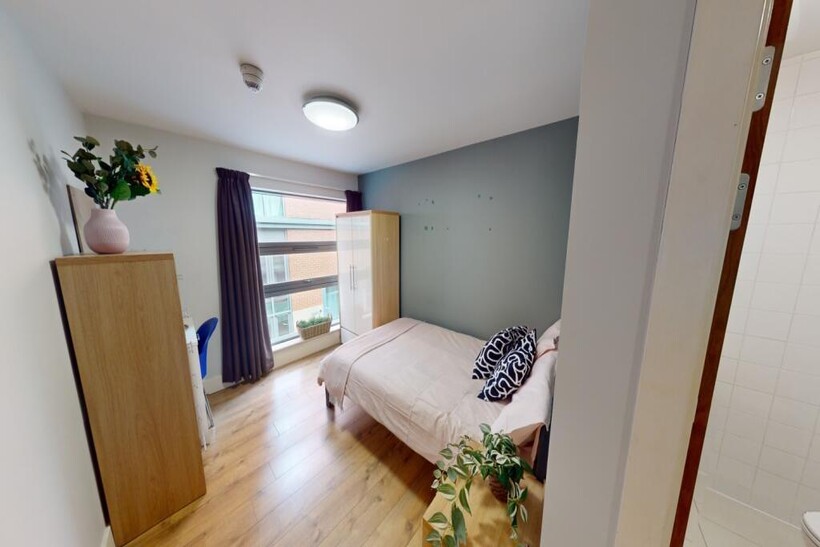 A bright and welcoming master bedroom featuring...