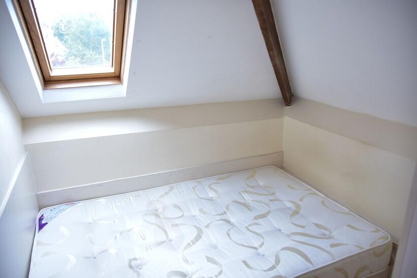 A compact single bedroom featuring a clean matt...