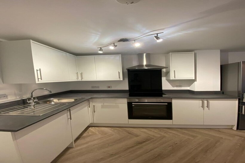 Modern kitchen with white cabinetry, stainless ...