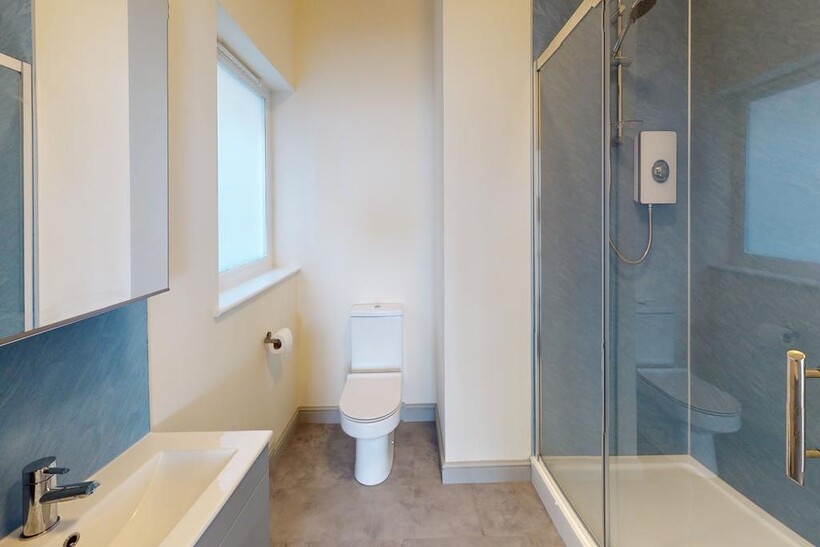 A modern, clean bathroom featuring a shower enc...