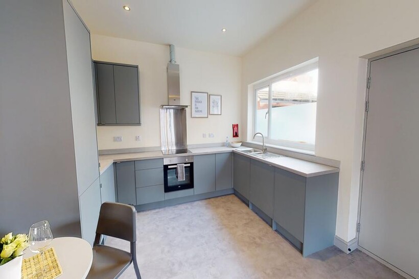 Modern, well-maintained kitchen with sleek grey...