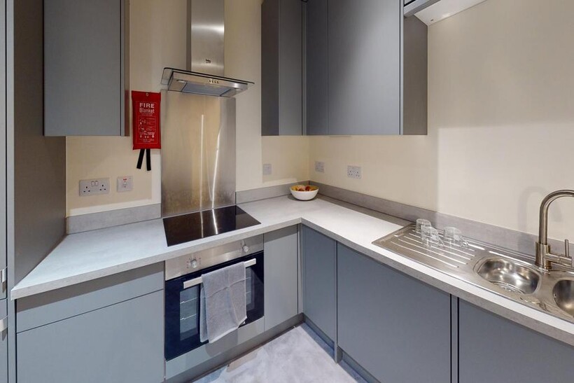 Modern and tidy kitchen featuring sleek gray ca...