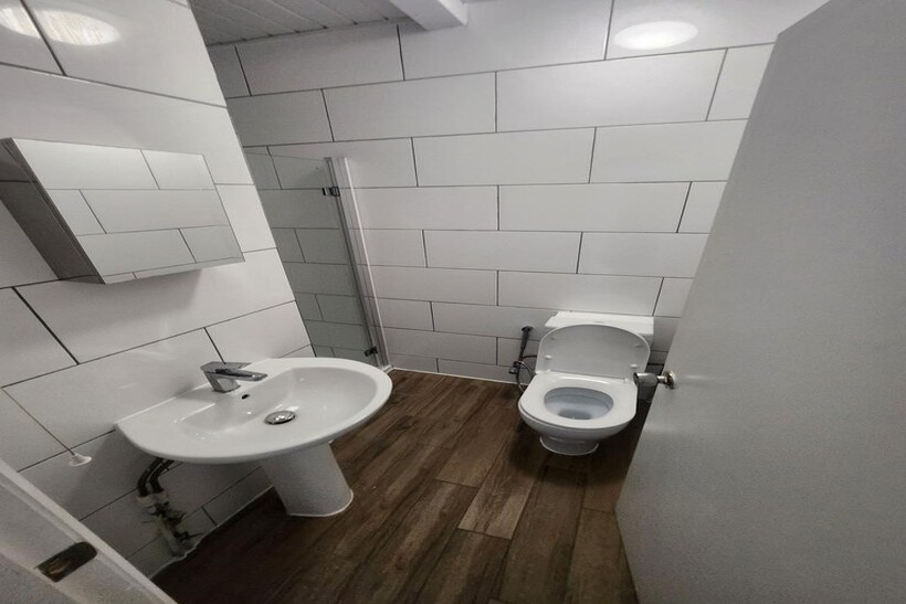 A clean, modern bathroom with white tiled walls...