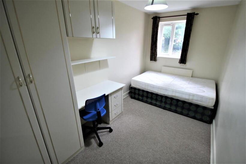 A bright and tidy single bedroom featuring a be...