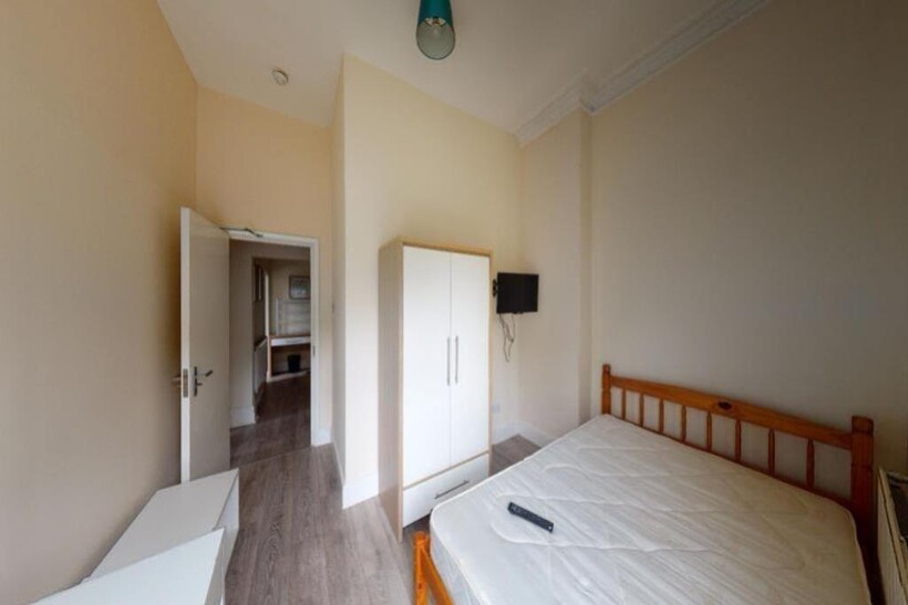 A bright and tidy single bedroom featuring a wo...