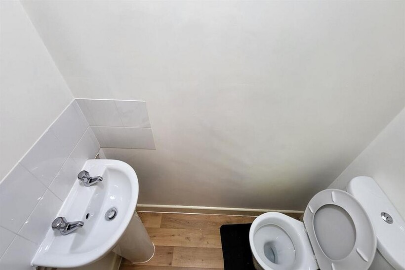 A clean and simple single toilet room featuring...