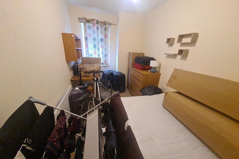 Cozy single bedroom featuring a neatly made bed...