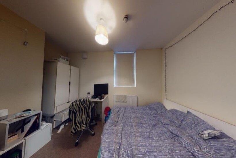 A simple and tidy single bedroom featuring a be...