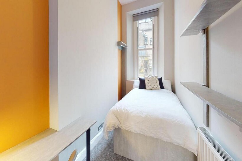 A bright and tidy single bedroom with modern de...