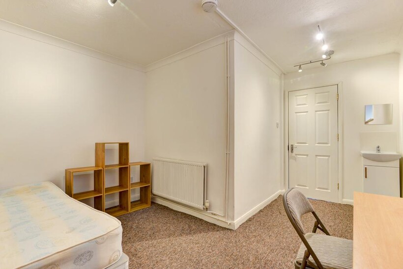 A neat and functional single bedroom featuring ...