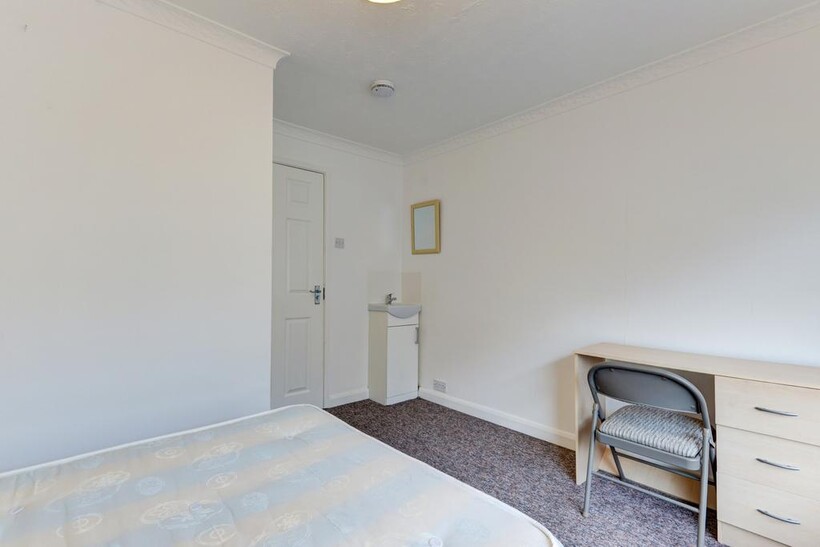 A bright and tidy single bedroom featuring a si...