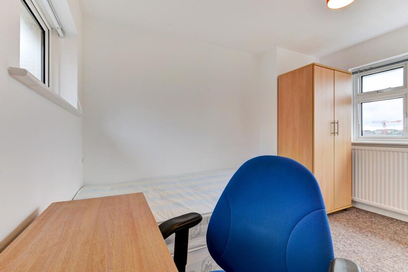 Bright and tidy single bedroom featuring a wood...