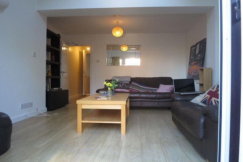 A spacious, well-lit living room featuring two ...