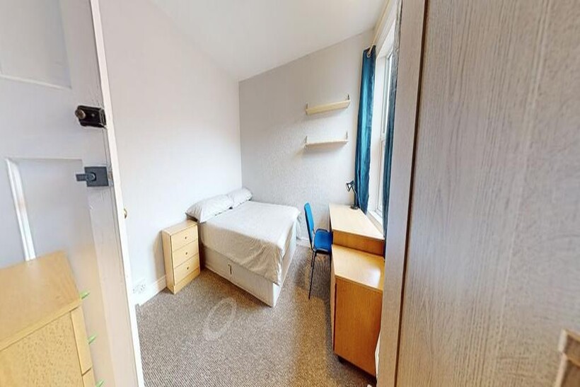 A cozy bedroom featuring a comfortable bed, a d...