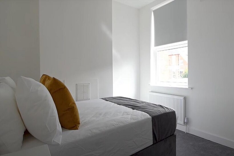 A bright and tidy bedroom featuring a comfortab...