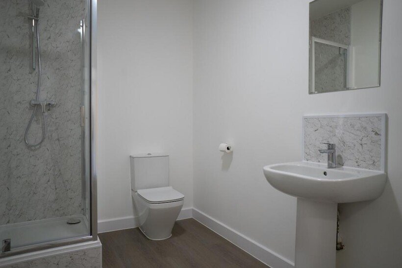 A clean and modern bathroom featuring a shower,...