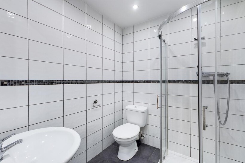 A modern and immaculate bathroom featuring a sl...