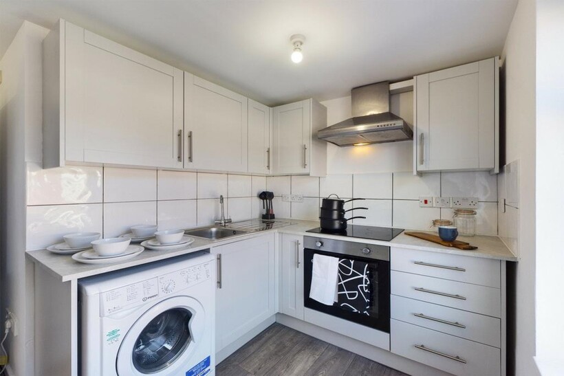 A modern and tidy kitchenette with ample storag...