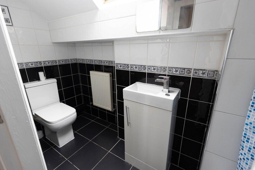 Modern bathroom with a toilet and a small sink,...