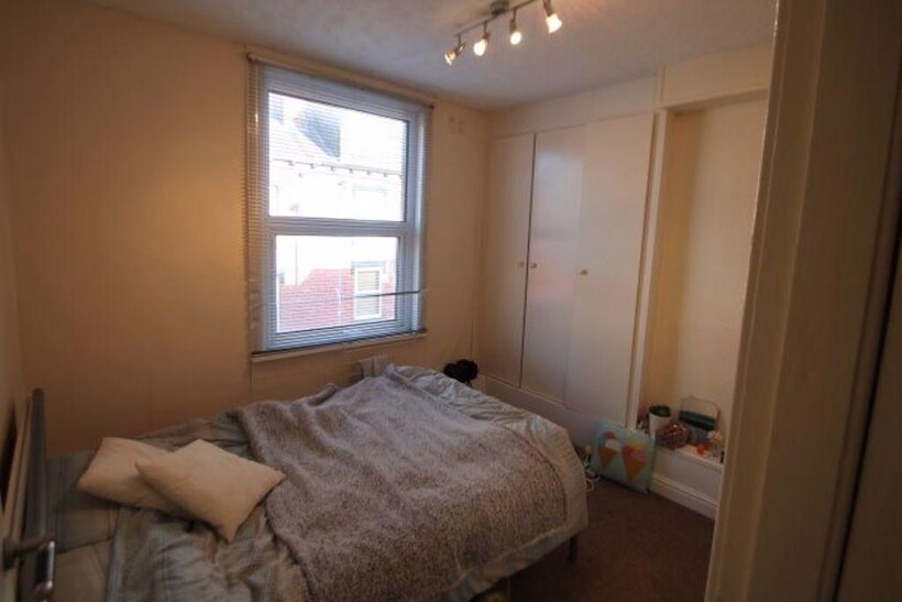 A cozy and well-maintained bedroom featuring a ...