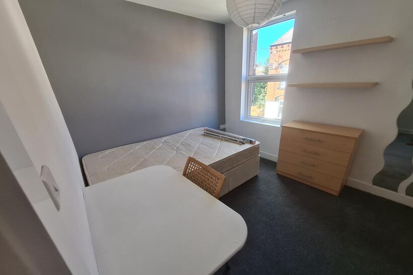 A bright and tidy single bedroom featuring a co...