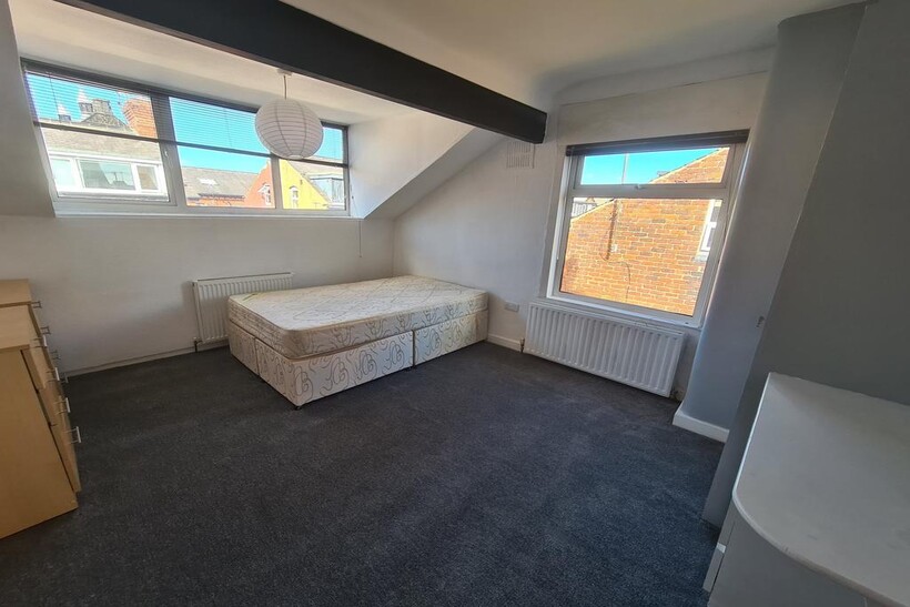 A bright and tidy single bedroom featuring two ...