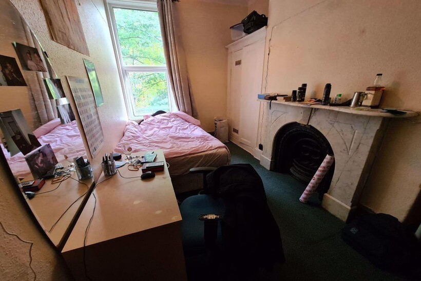 Cozy bedroom featuring a large window providing...