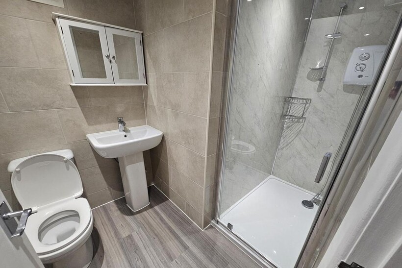 A modern, tidy bathroom with a large shower enc...