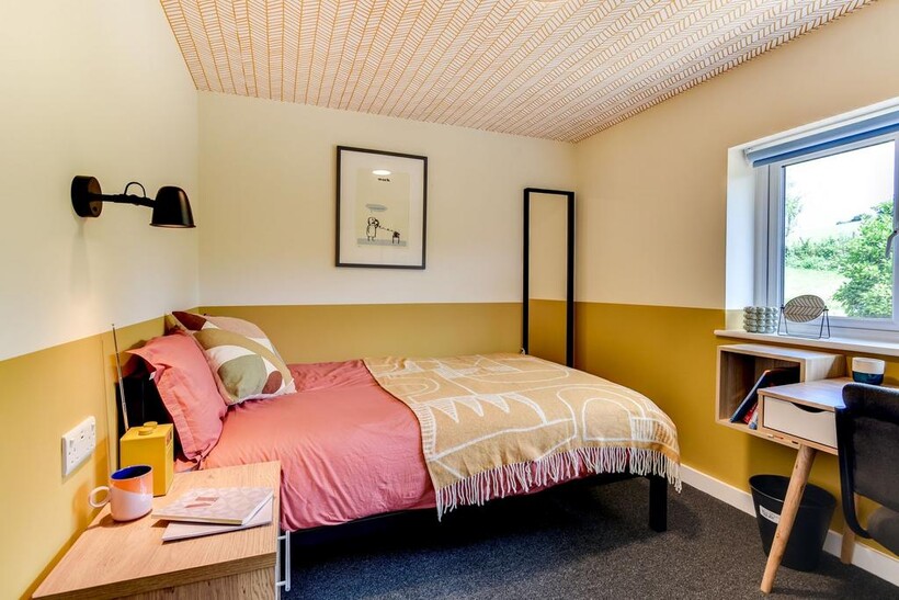 A cozy single bedroom featuring a comfortable b...